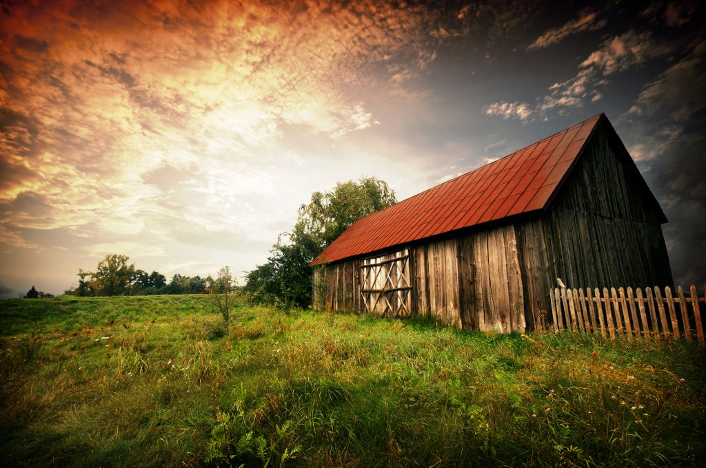 Sunset by an old barn Old wooden bar with red roof over the dramatic sunset. Zalew Zegrzynski, Poland