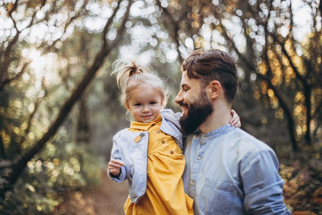 Nik 1 young, stylish bearded father walking with his little daughter in nature at sunset. Family photos of father and one child. selective focus, noise effect